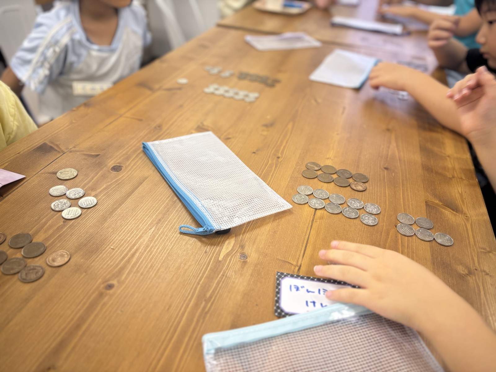販売後に硬貨を数えて売上を確認するこどもたち